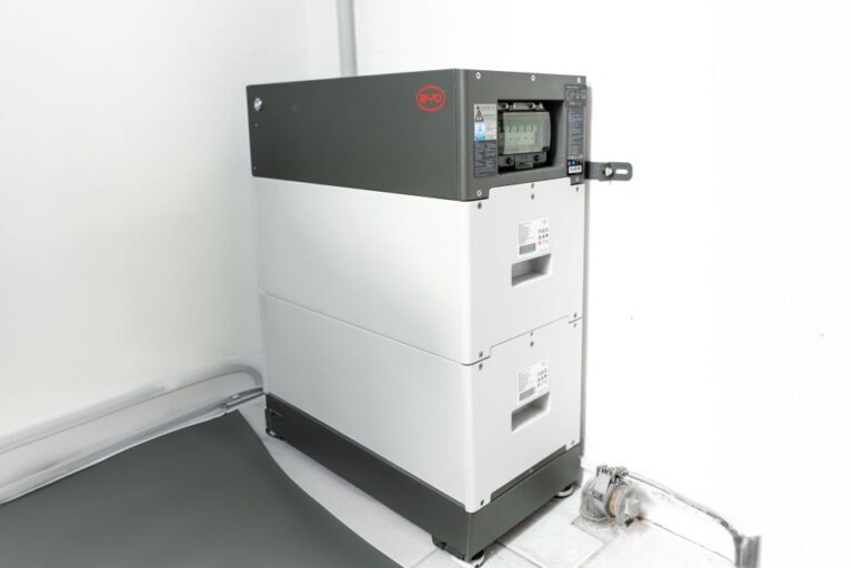 Ein wei&szlig;-grauer industrieller Batteriespeicher mit Digitalanzeige, installiert in einem sauberen Innenraum.